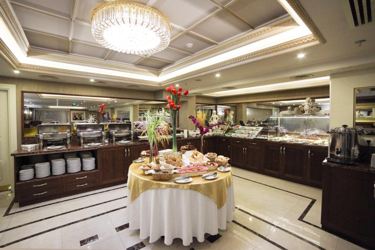 een restaurant met een tafel midden in de keuken bij Halifaks Hotel in Istanbul