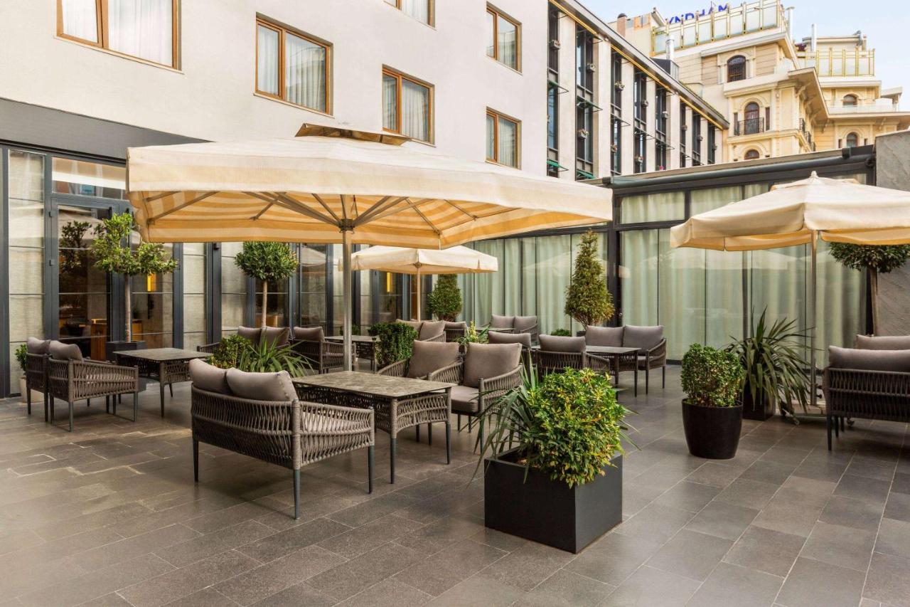 een terras buiten met tafels, stoelen en parasols bij Ramada Plaza By Wyndham Istanbul Sultanahmet in Istanbul