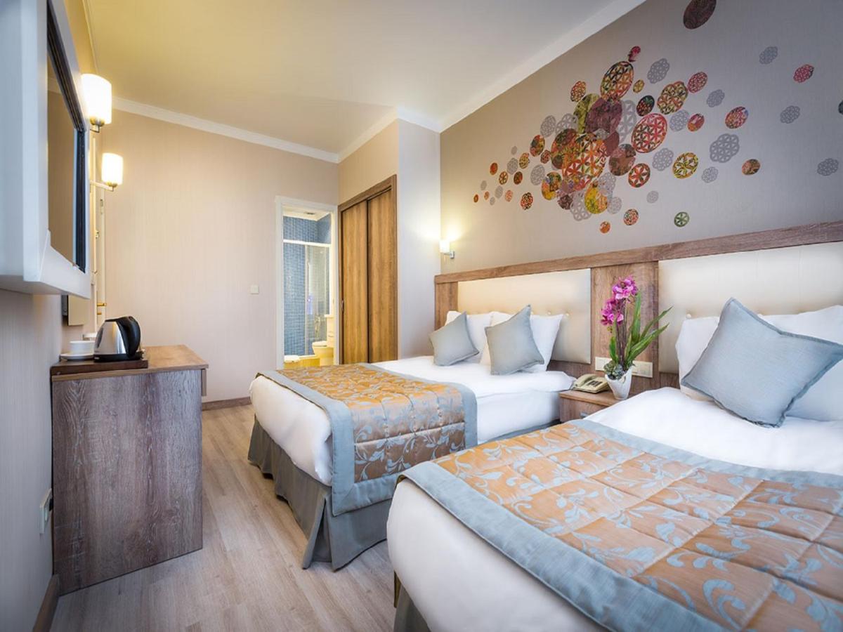 een hotelkamer met twee bedden en een televisie bij Fatih Hotel Corner in Istanbul
