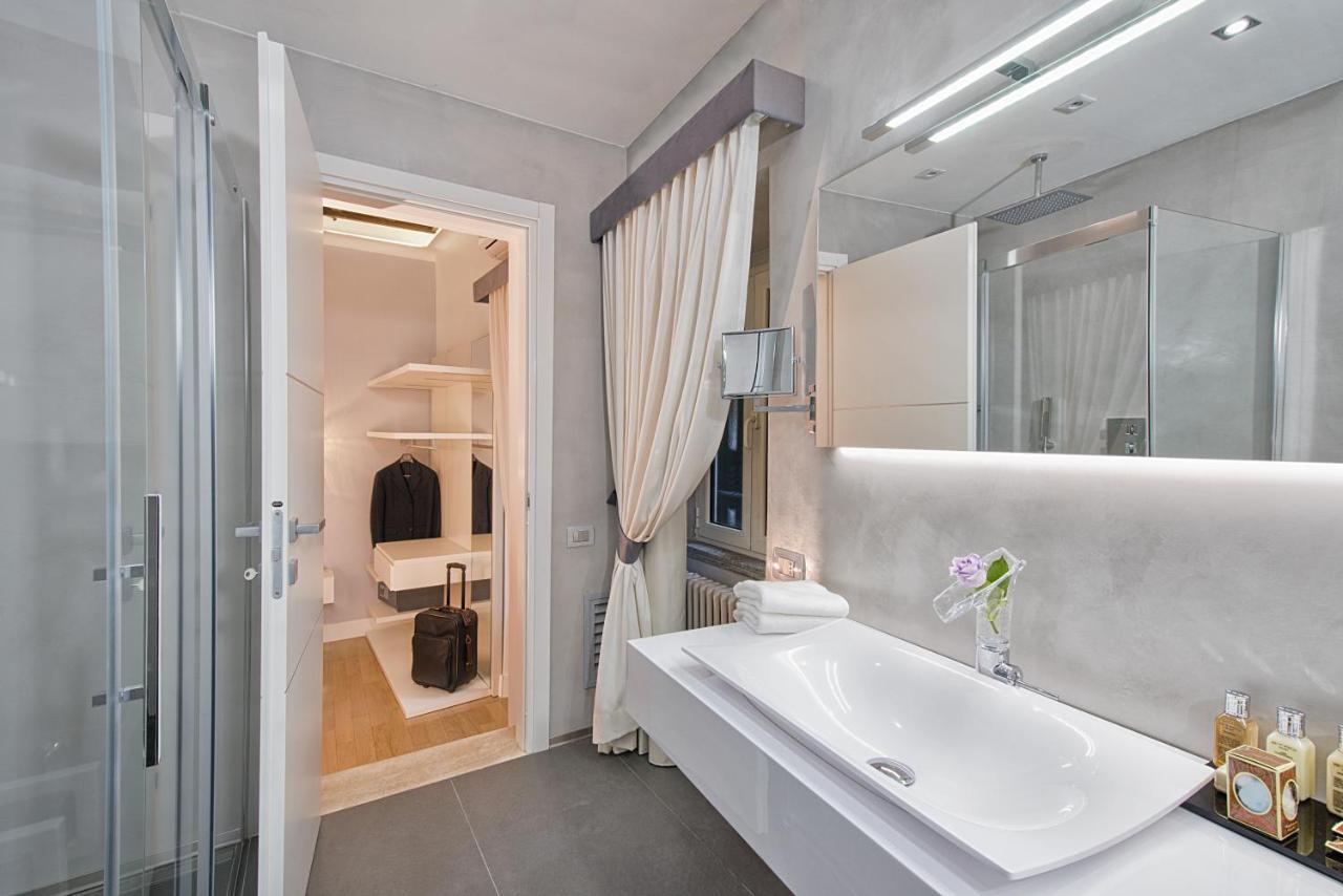 een witte badkamer met een wastafel en een spiegel bij Domus Libera in Rome +20 foto's