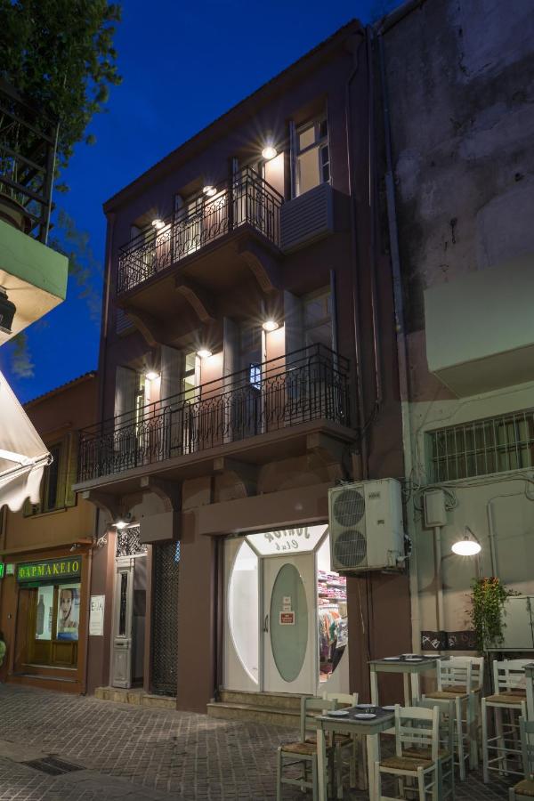 een gebouw met een balkon met tafels en stoelen bij Elia Daliani in Chania