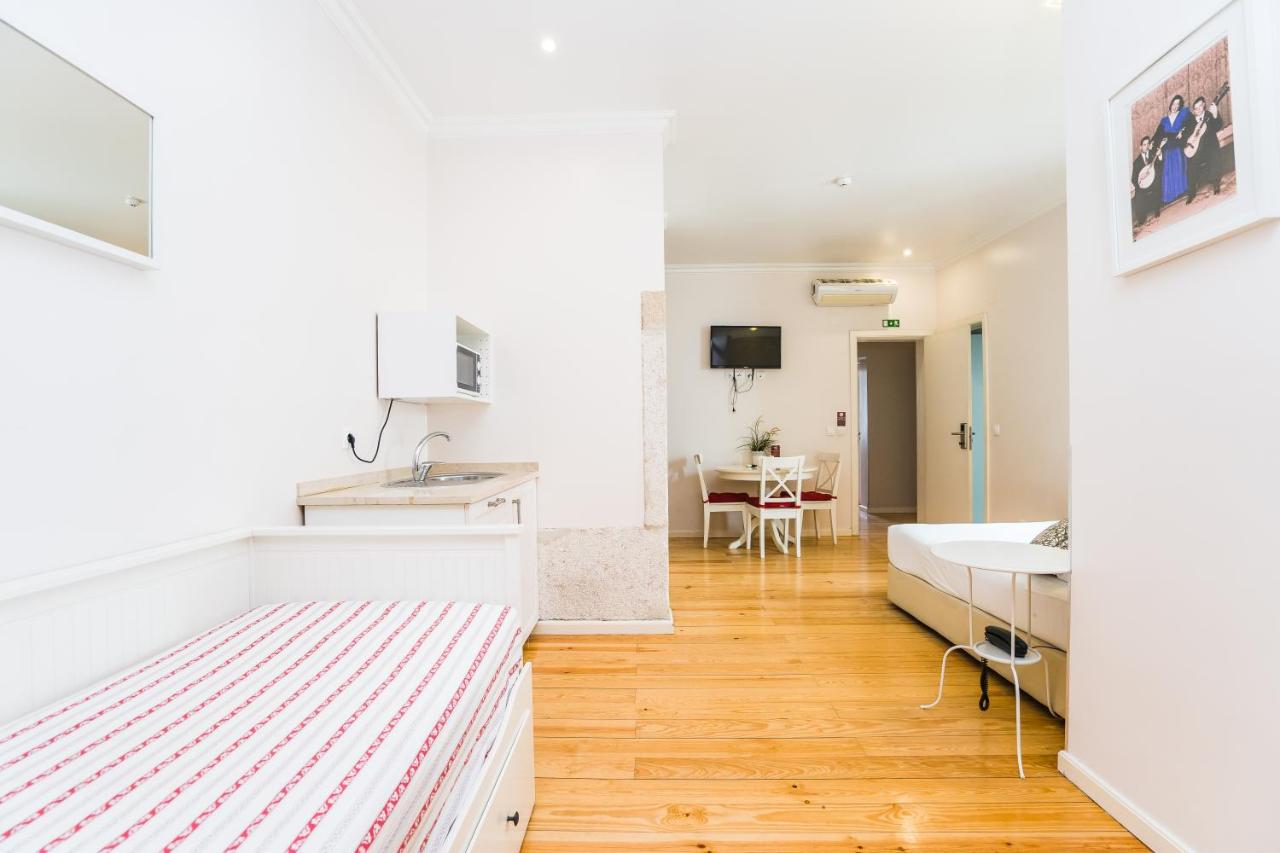 een keuken en woonkamer met een bed en een tafel bij Lisbon Arsenal Suites in Lissabon