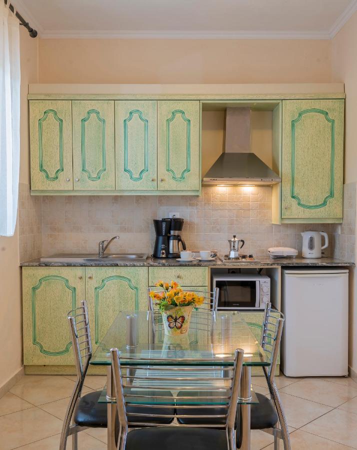een keuken met een glazen tafel en stoelen erin bij Ziogas Luxury Apartments in Dassia