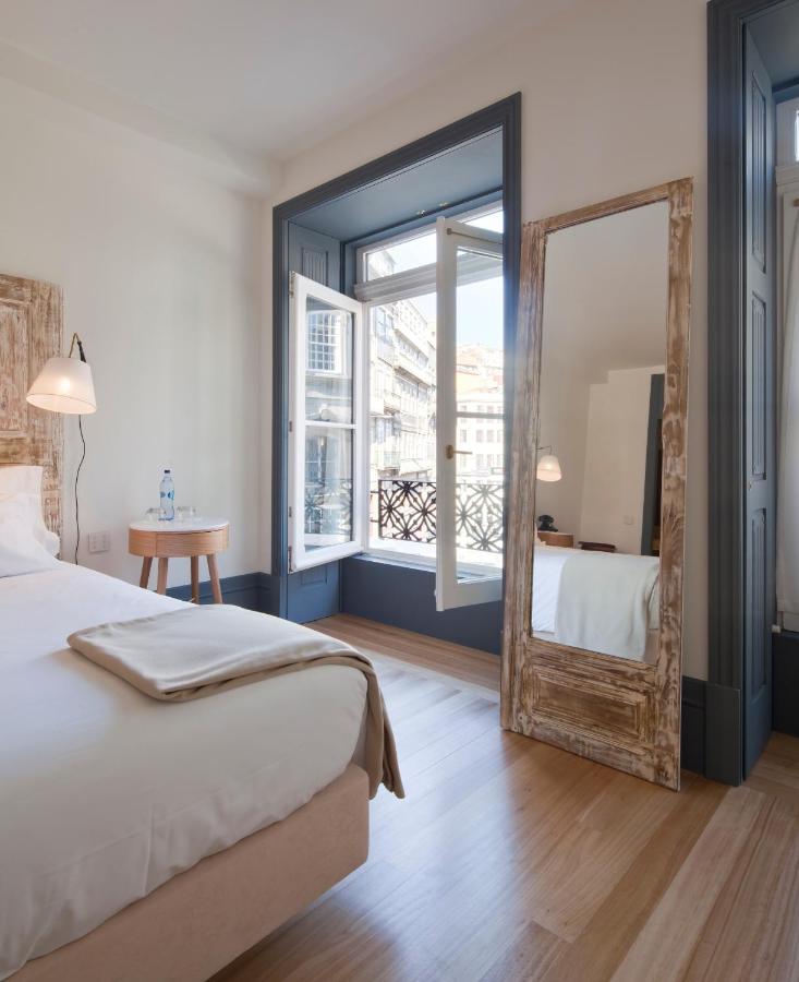 een slaapkamer met een spiegel, een bed en een raam bij Porto A.S. 1829 Hotel in Porto