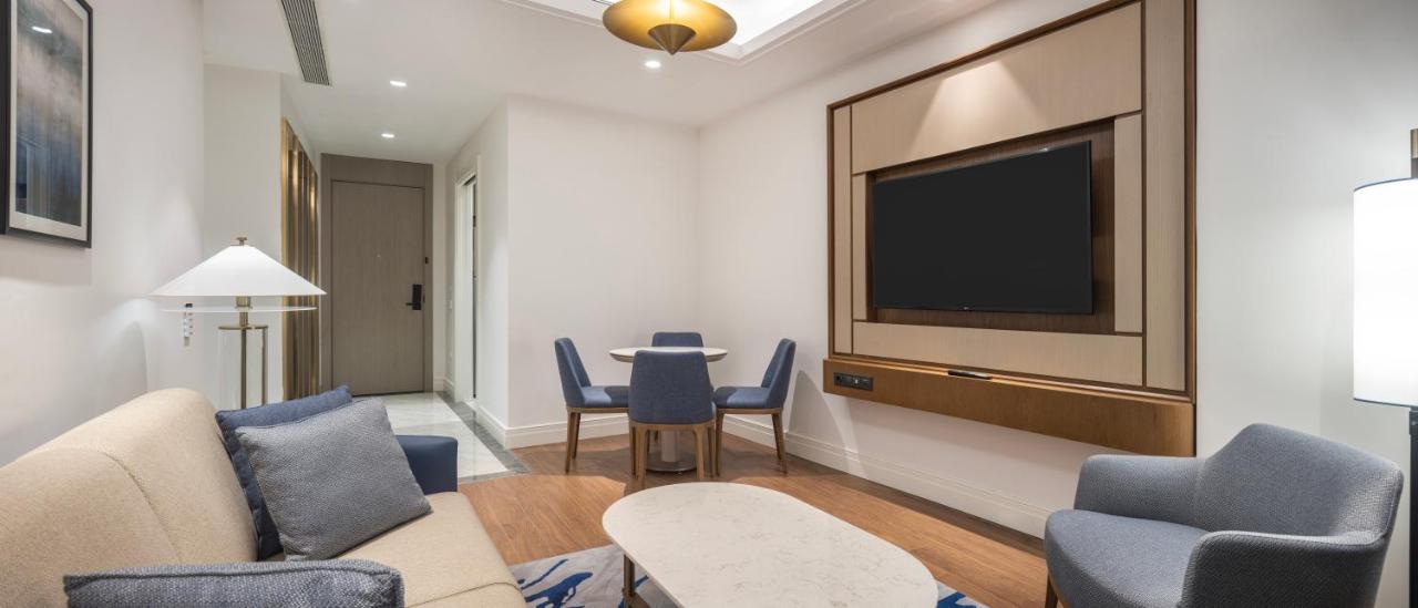 een woonkamer met een tv, een tafel en stoelen bij Hilton Mall Of Istanbul in Istanbul