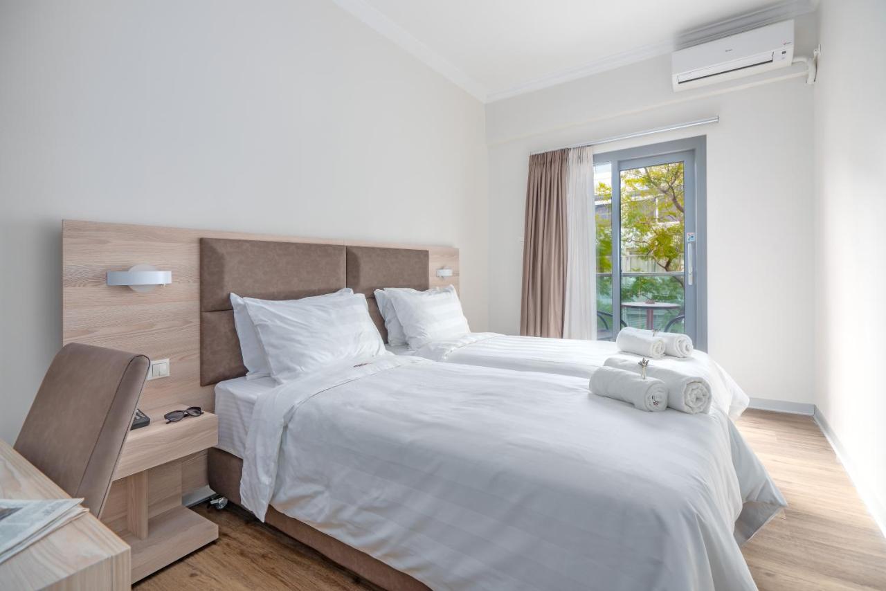 een slaapkamer met twee bedden en een raam bij Attalos Hotel in Athene