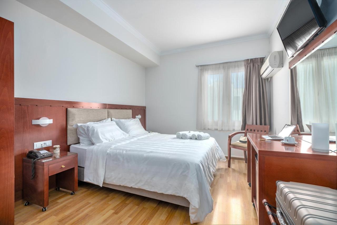 een slaapkamer met een bed, een bureau en een televisie bij Attalos Hotel in Athene