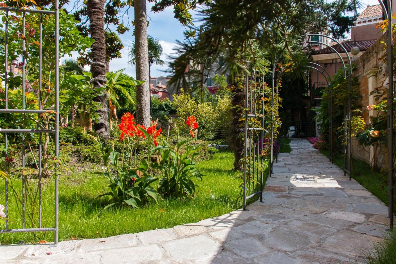een tuin met rode bloemen en een pad bij Hotel Sant'Antonin in Venetië