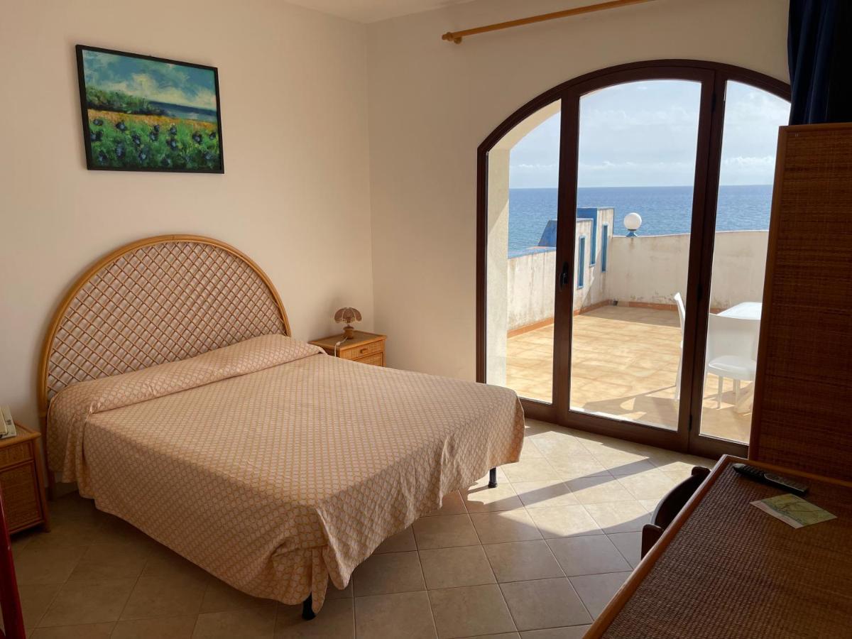 een slaapkamer met een bed en uitzicht op de oceaan bij Hotel Miramare Garzia in Marinella di Selinunte
