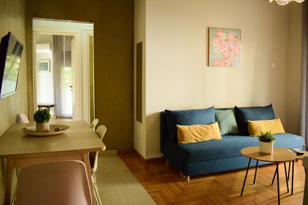 een woonkamer met een blauwe bank en een tafel bij 2BA under the Acropolis Hill Athens City Center in Athene