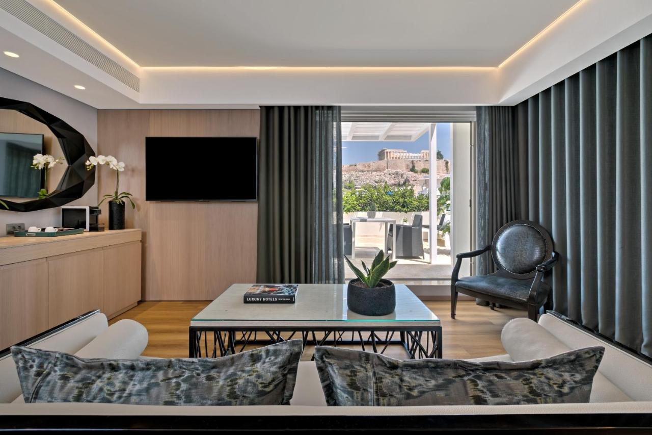 een woonkamer met een bank en een tafel bij Divani Palace Acropolis in Athene