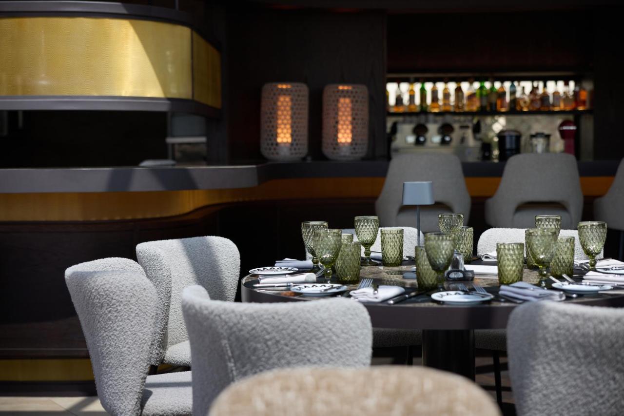 een eetkamer met een tafel en stoelen en een bar bij Divani Palace Acropolis in Athene