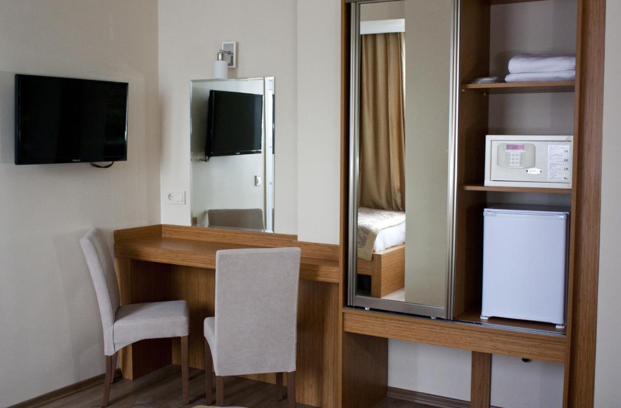 een kamer met een bureau met een spiegel en een magnetron bij Istanbul Central Hotel in Istanbul