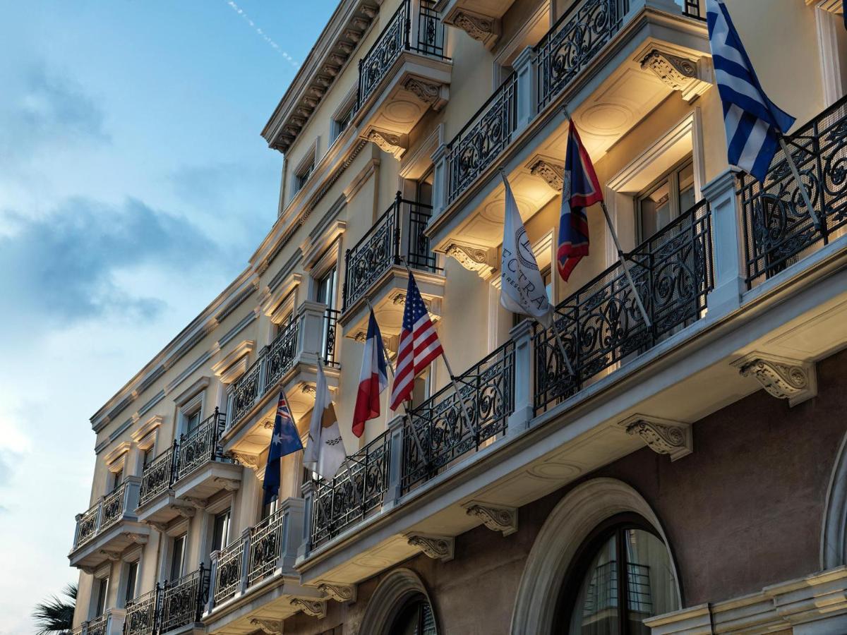 een gebouw met Amerikaanse vlaggen op de balkons bij Electra Palace Athens in Athene