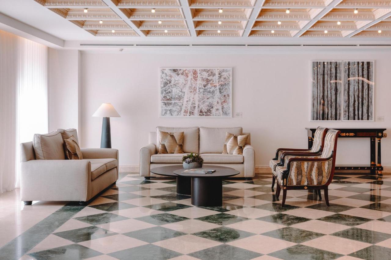 een woonkamer met een bank en een tafel bij Electra Palace Athens in Athene