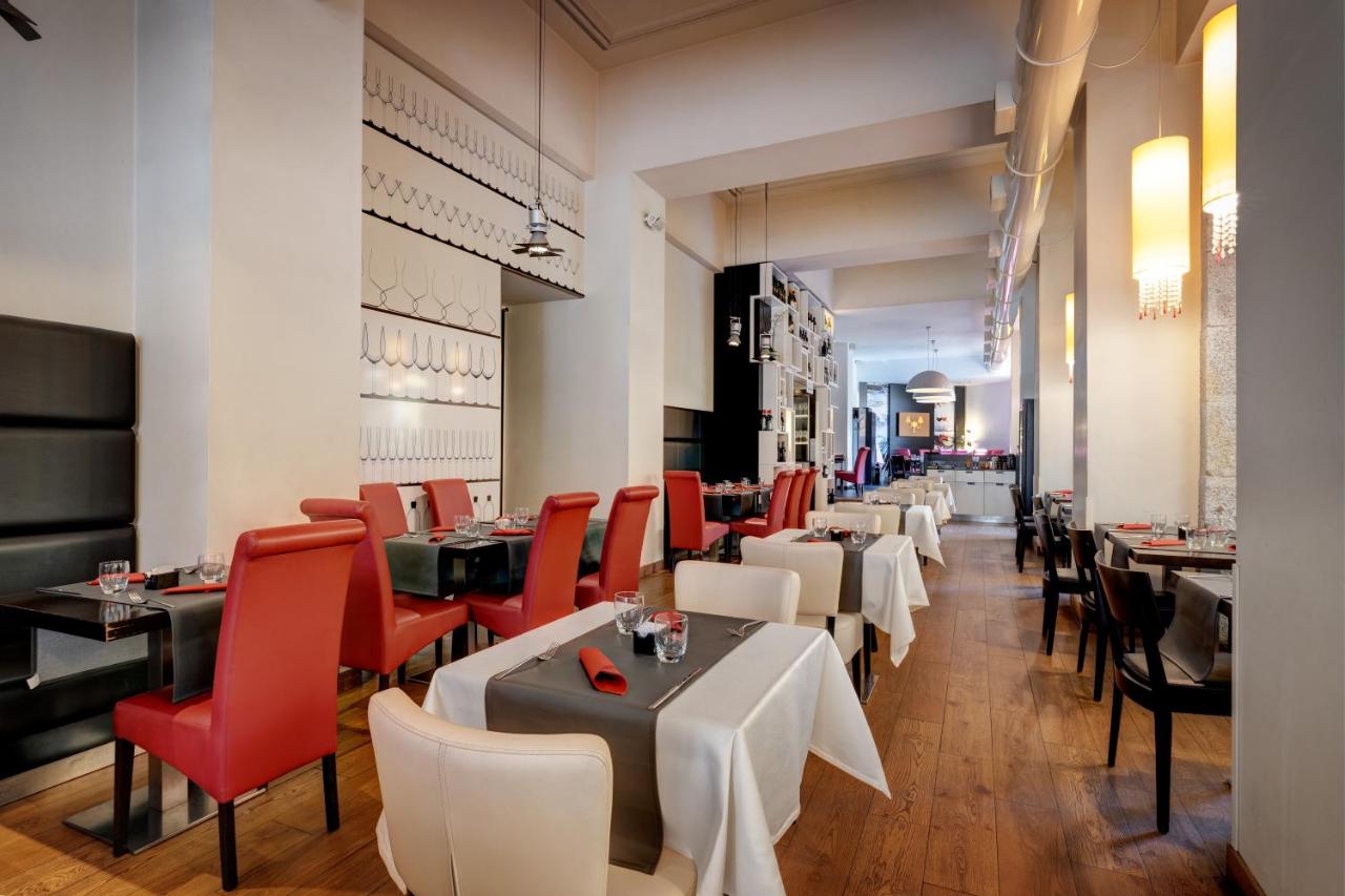 een restaurant met witte tafels en rode stoelen bij Dharma Luxury Hotel & SPA in Rome