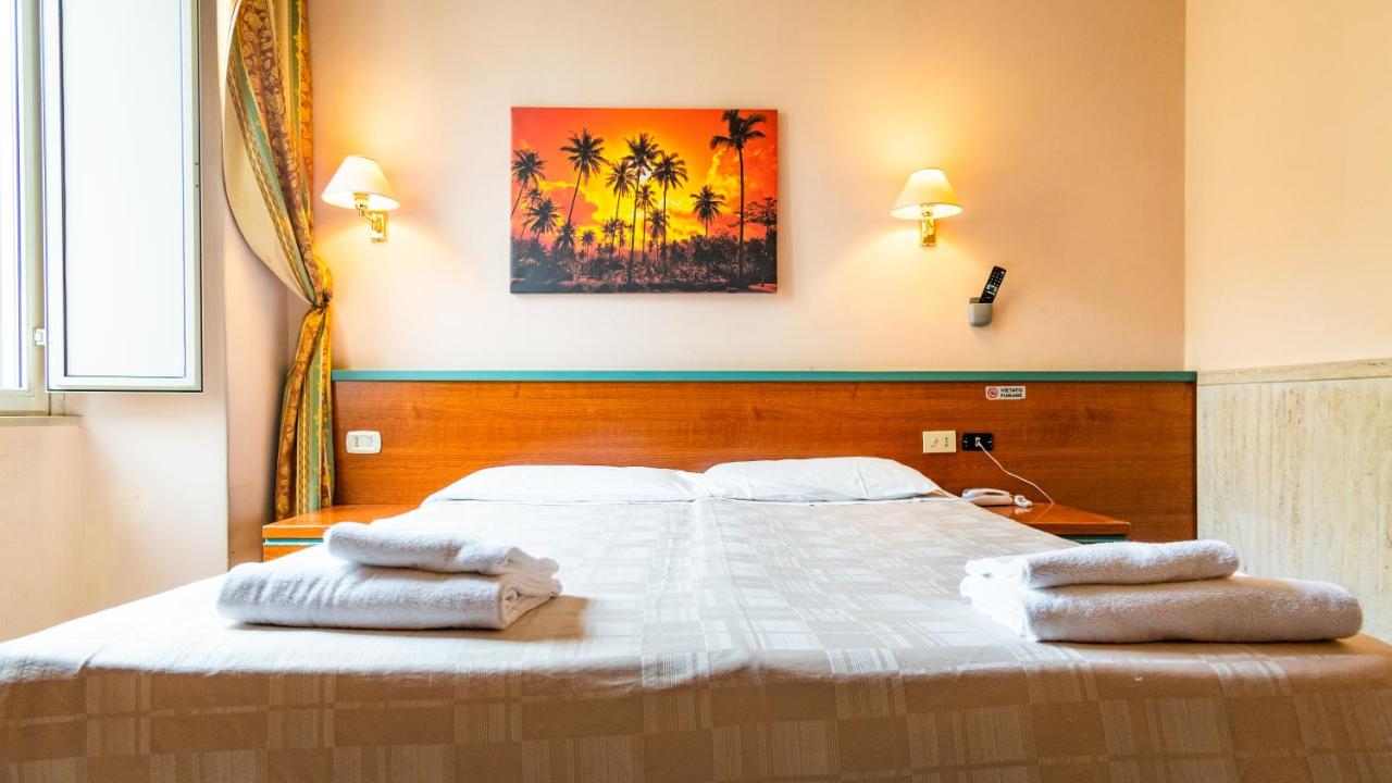 een slaapkamer met een groot bed en handdoeken erop bij Hotel Center 3 in Rome