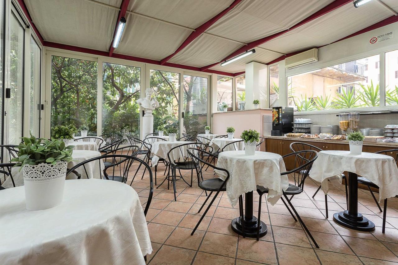 een restaurant met witte tafels en stoelen en ramen bij Hotel Center 3 in Rome