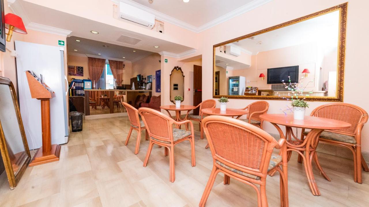 een eetkamer met tafels en stoelen en een spiegel bij Hotel Center 3 in Rome