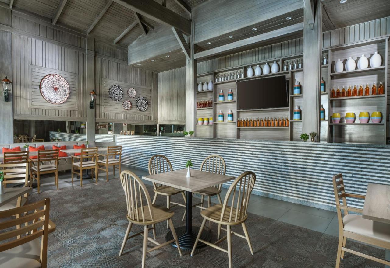 een restaurant met tafels en stoelen en een tv bij JAZ Fanara Residence in Sharm El Sheikh +33 foto's