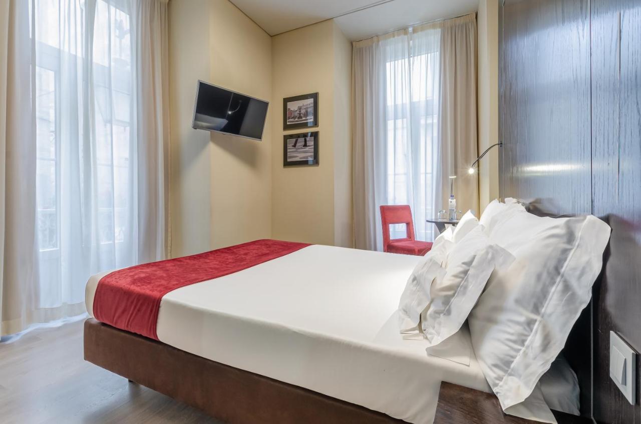 een slaapkamer met een bed en een bureau in een kamer bij behotelisboa in Lissabon