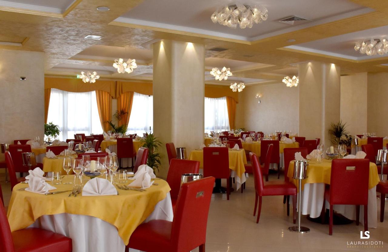 een eetkamer met gele tafels en rode stoelen bij Hotel Riviera Azzurra in Oliveri