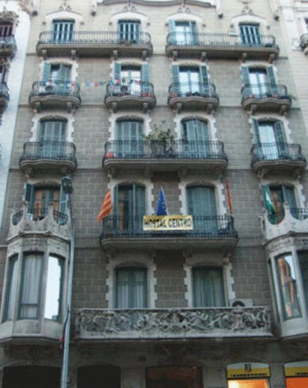 een hoog gebouw met balkons en een uithangbord. bij Hostal Balmes Centro in Barcelona
