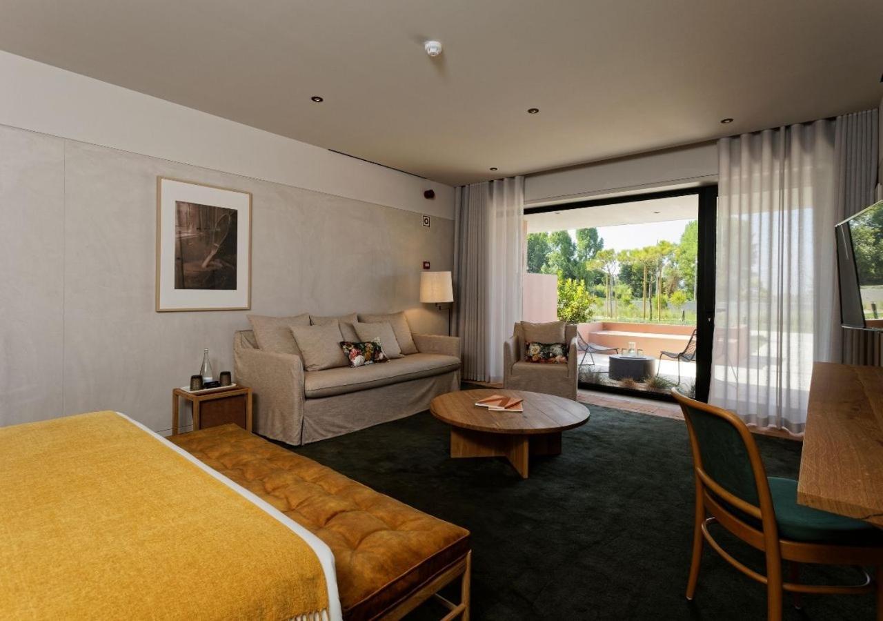 een hotelkamer met een bed en een bank bij Montebelo Vista Alegre Ílhavo Hotel in Ílhavo