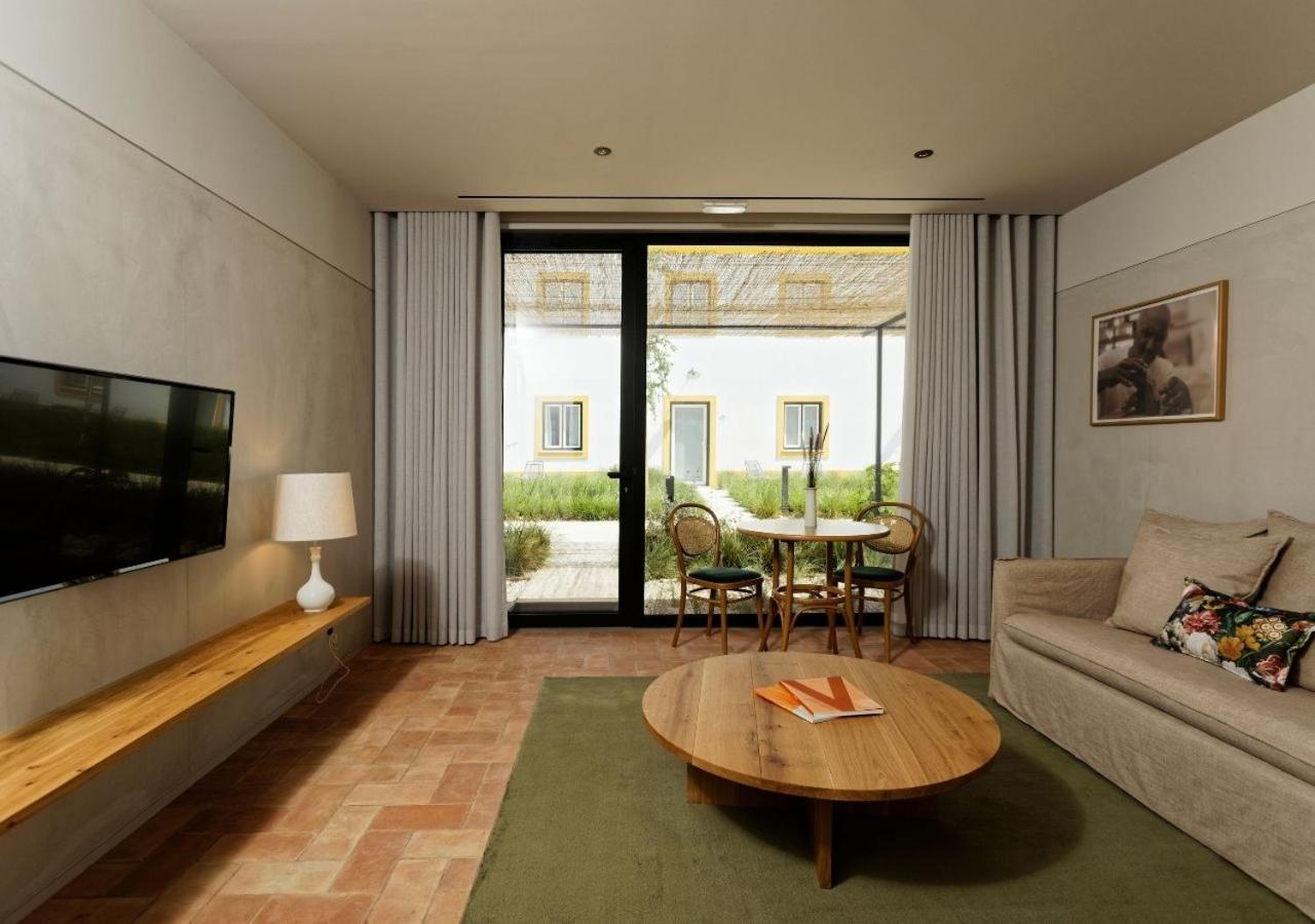 een woonkamer met een bank en een tafel bij Montebelo Vista Alegre Ílhavo Hotel in Ílhavo