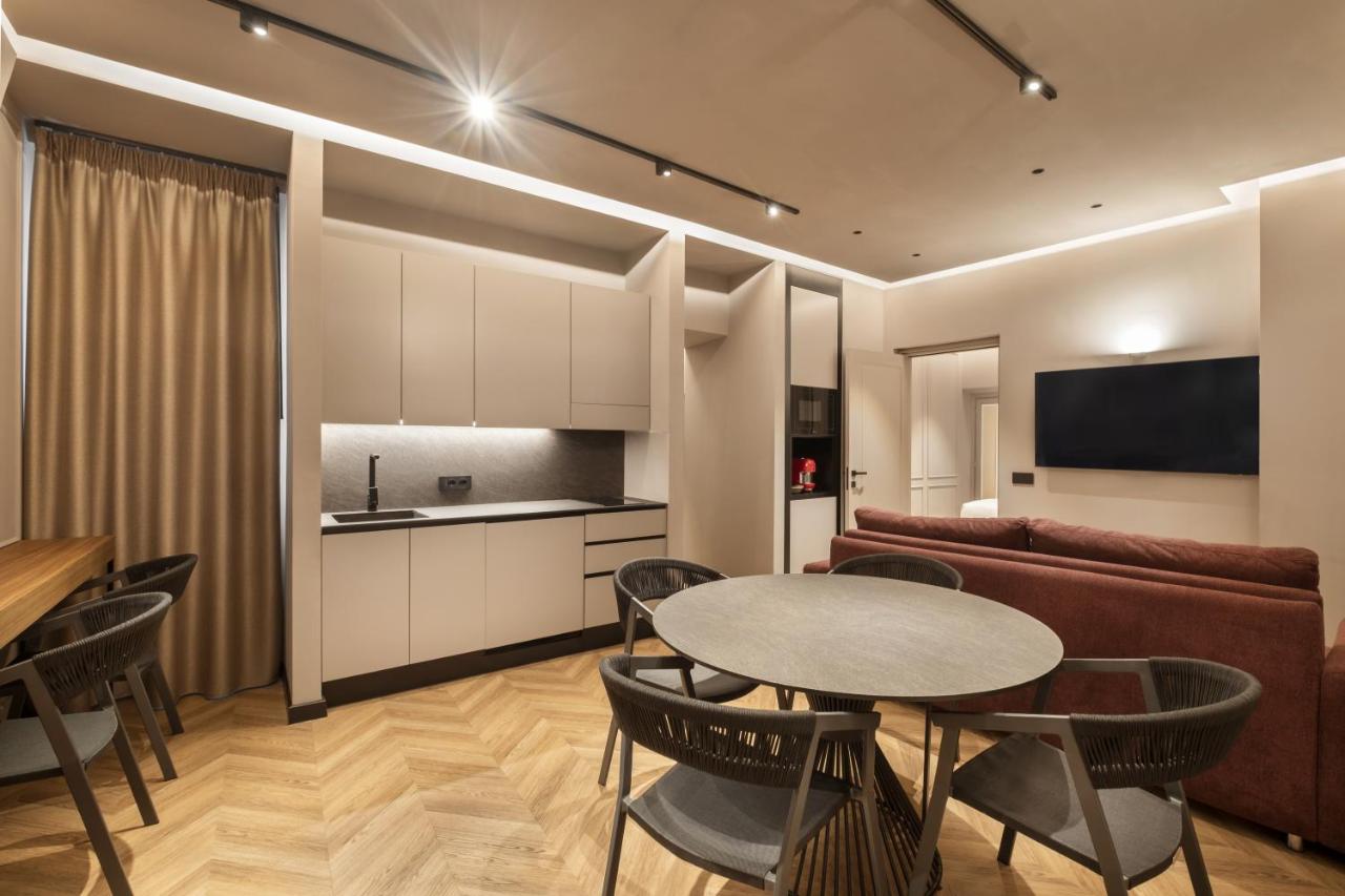 een woonkamer met een tafel, stoelen en een bank bij Oriana Homèl Roma in Rome