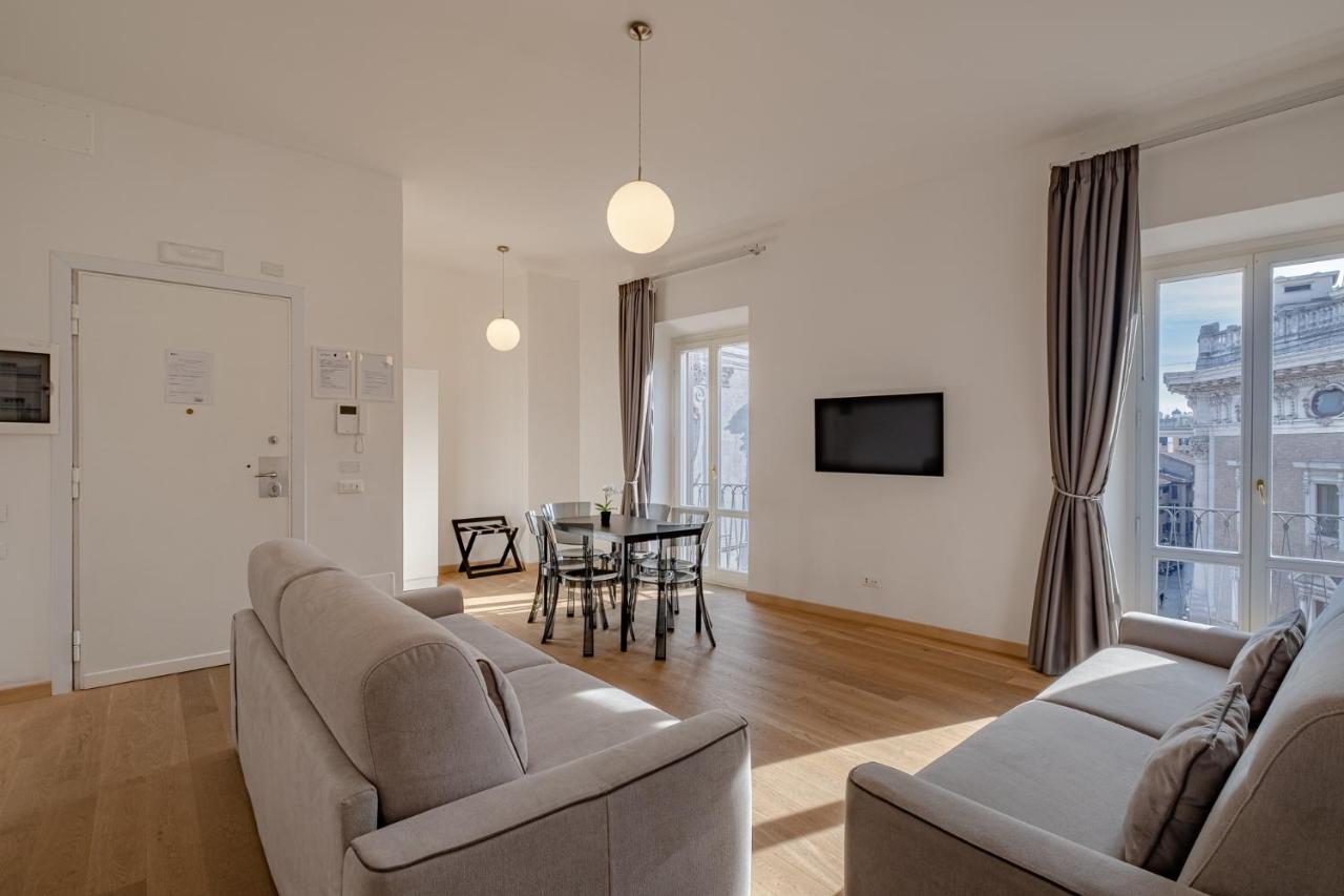 een woonkamer met twee banken en een tafel bij Oriana Homèl Roma in Rome