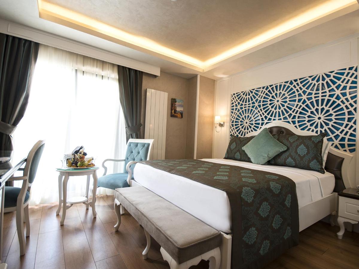 een hotelkamer met een groot bed en een tafel bij Antusa Palace Hotel & Spa in Istanbul