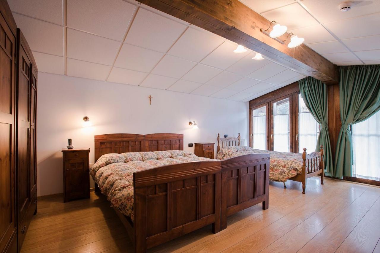 een slaapkamer met twee bedden en een groot raam bij GH Hotel Fratazza in San Martino di Castrozza