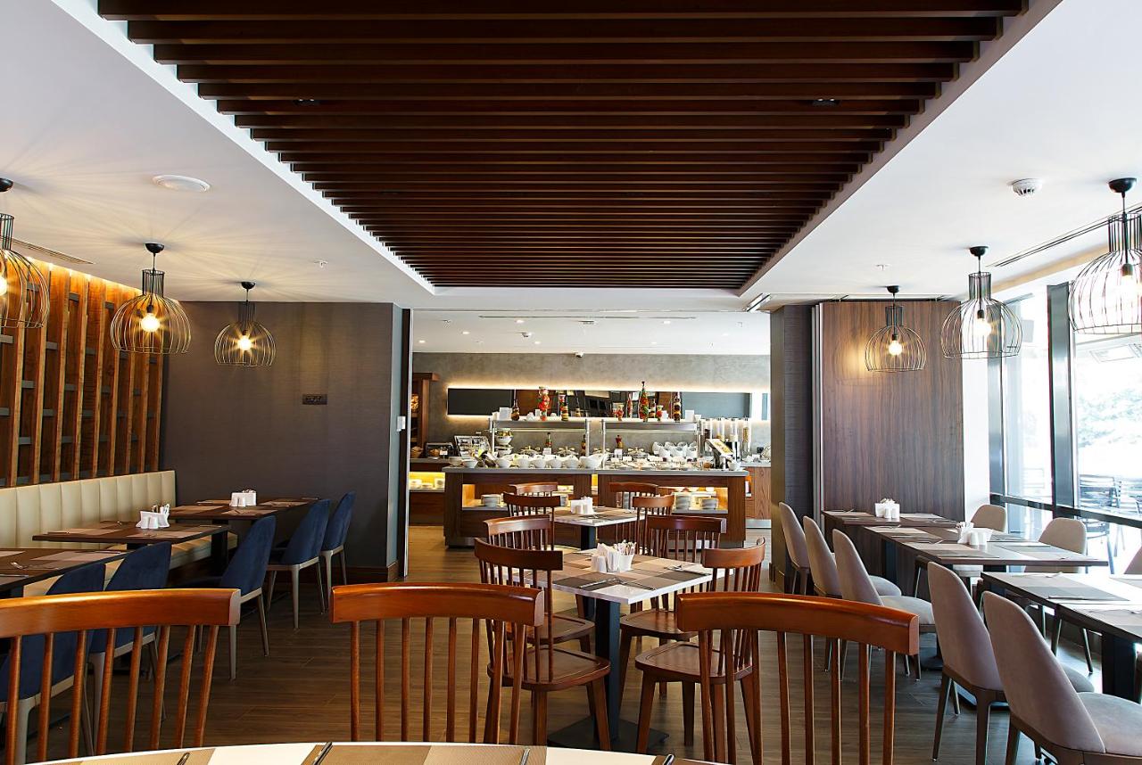 een restaurant met tafels en stoelen en een bar bij Bof Hotels Business in Istanbul