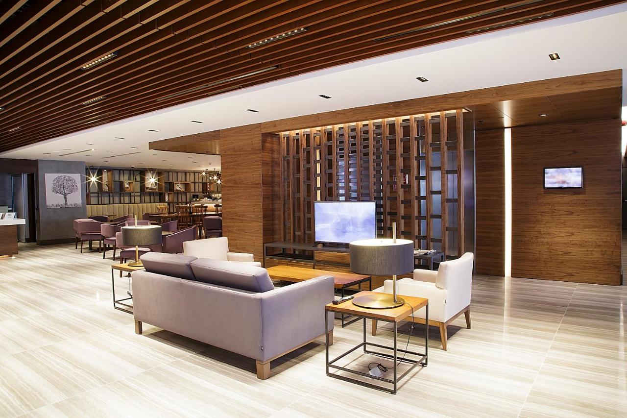 een lobby met banken en stoelen en een televisie bij Bof Hotels Business in Istanbul