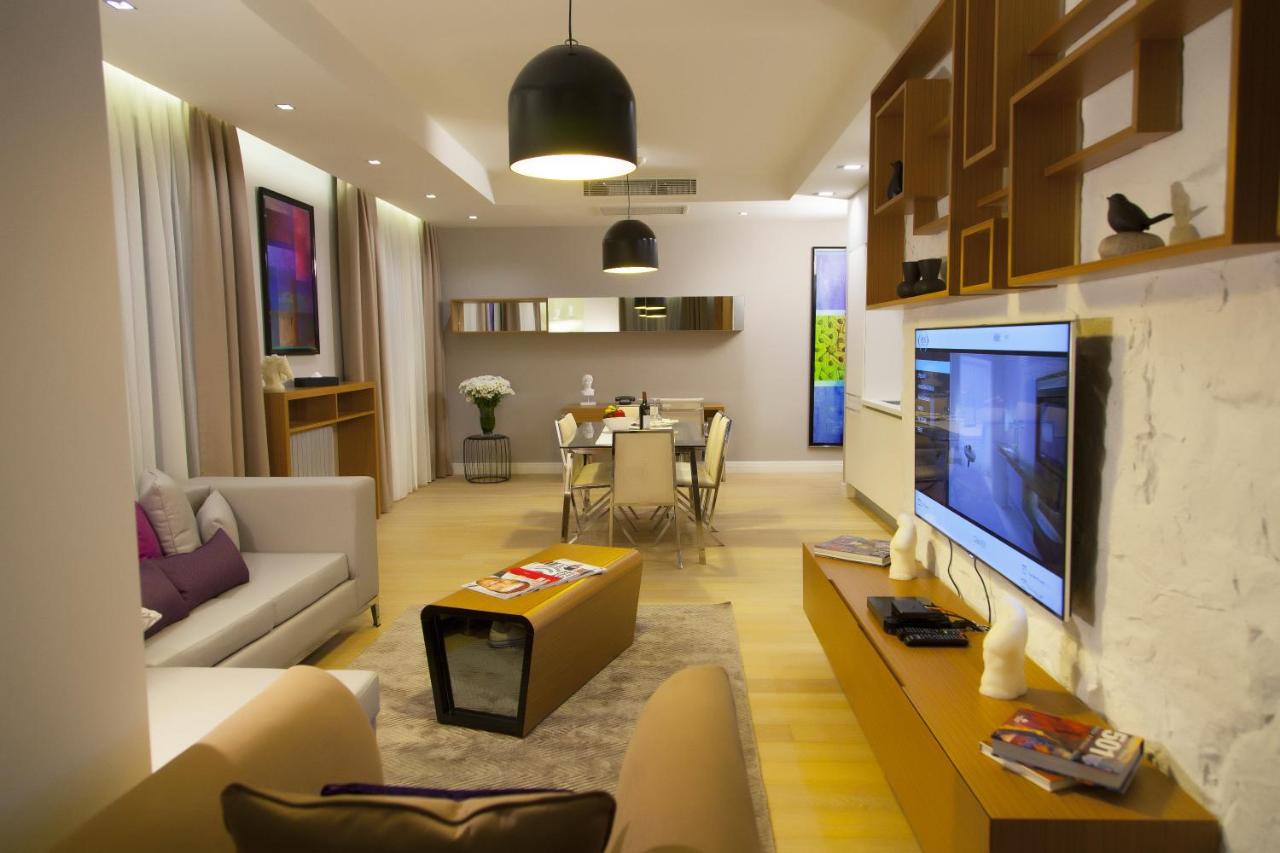 een woonkamer met een televisie en een woonkamer met een tafel bij The Leos Residence in Istanbul