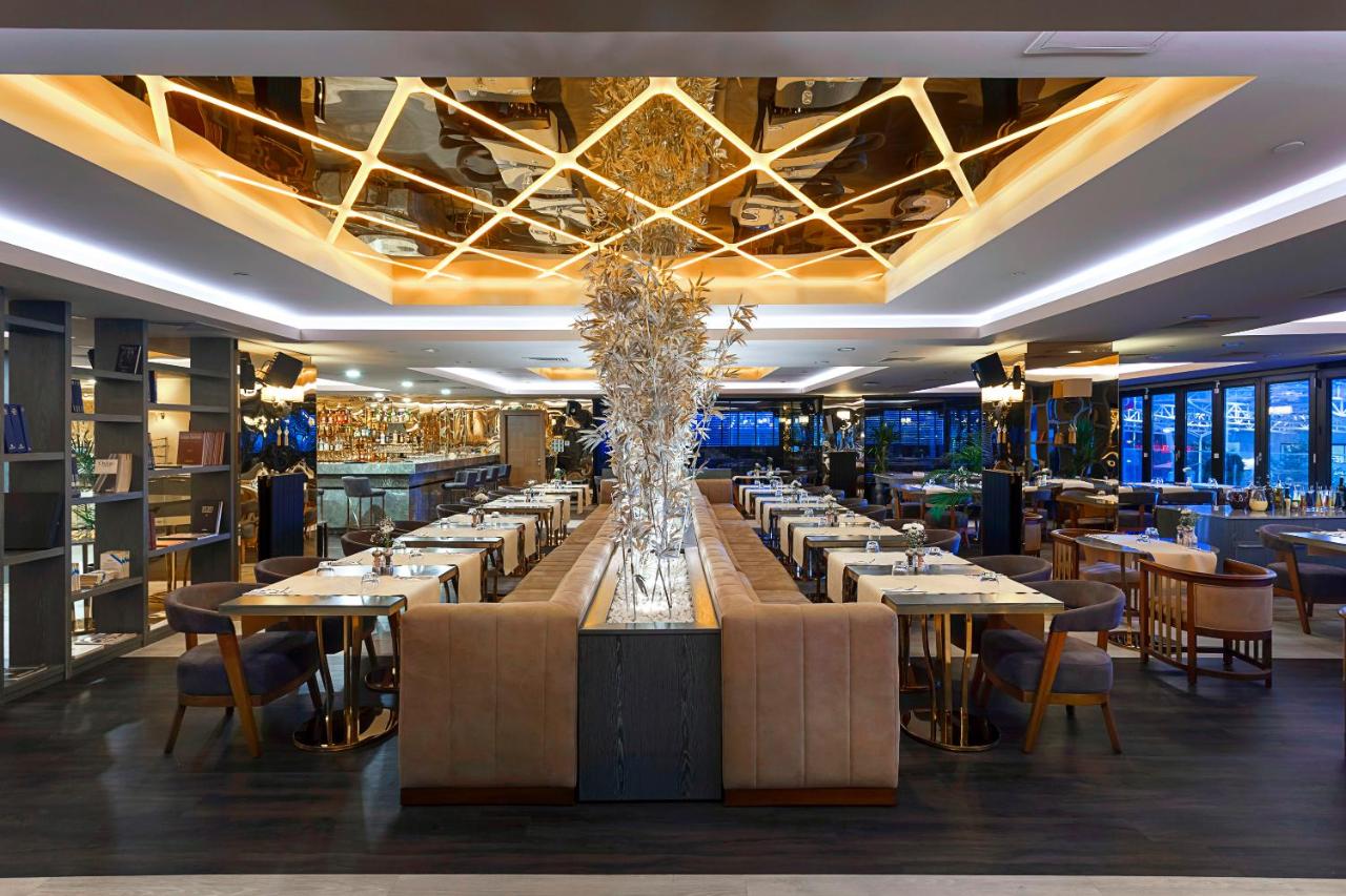 een eetkamer met tafels en stoelen en een grote lange tafel bij Nidya Hotel Esenyurt in Istanbul