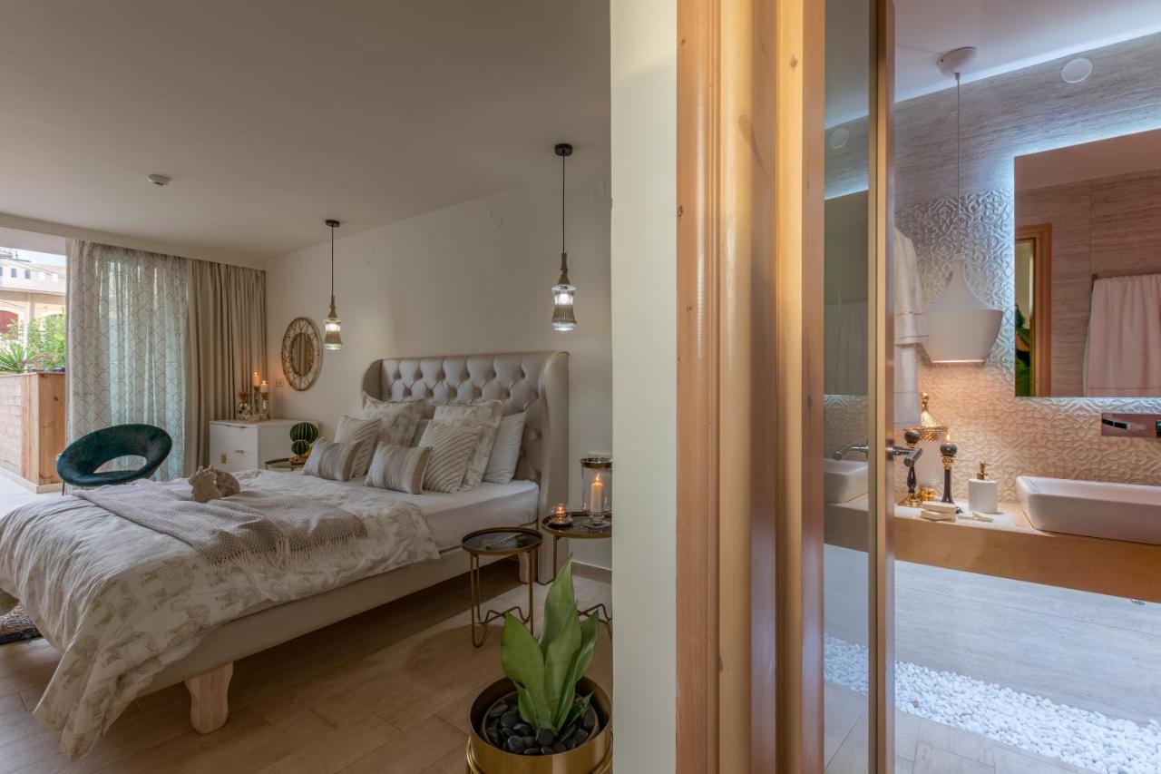 een slaapkamer met een groot bed en een badkamer bij Stelios Gardens in Malia