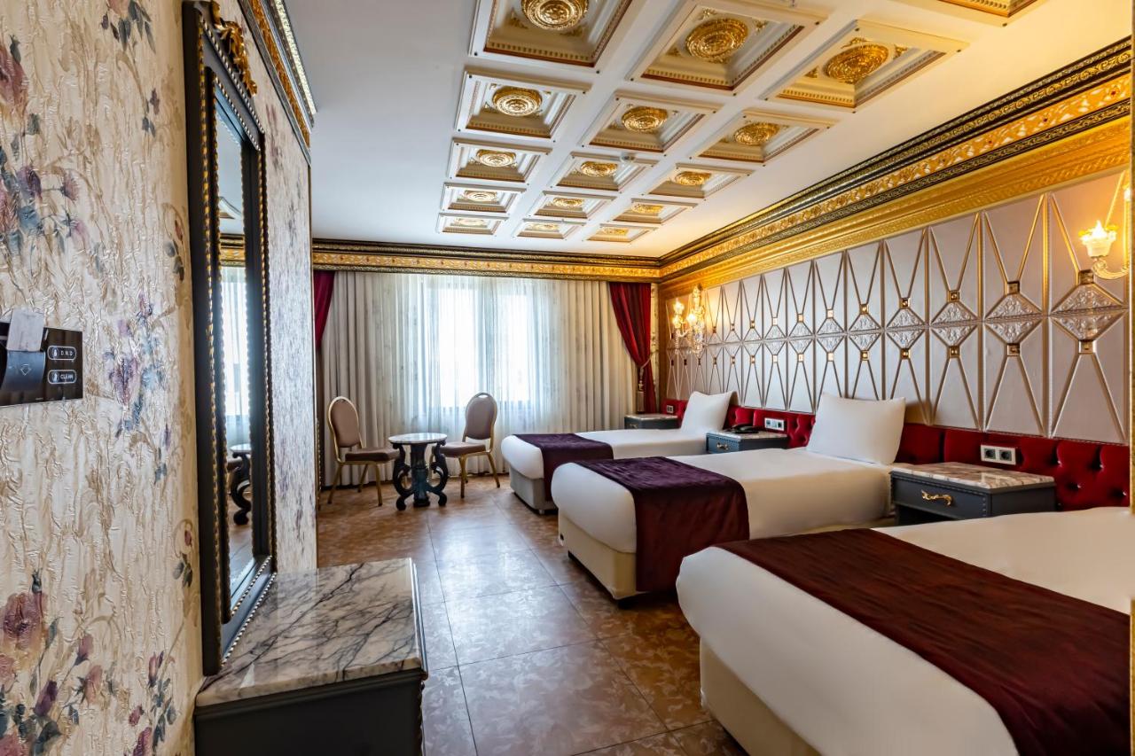 een hotelkamer met drie bedden en een bank bij Laleli Blue Marmaray Hotel in Istanbul