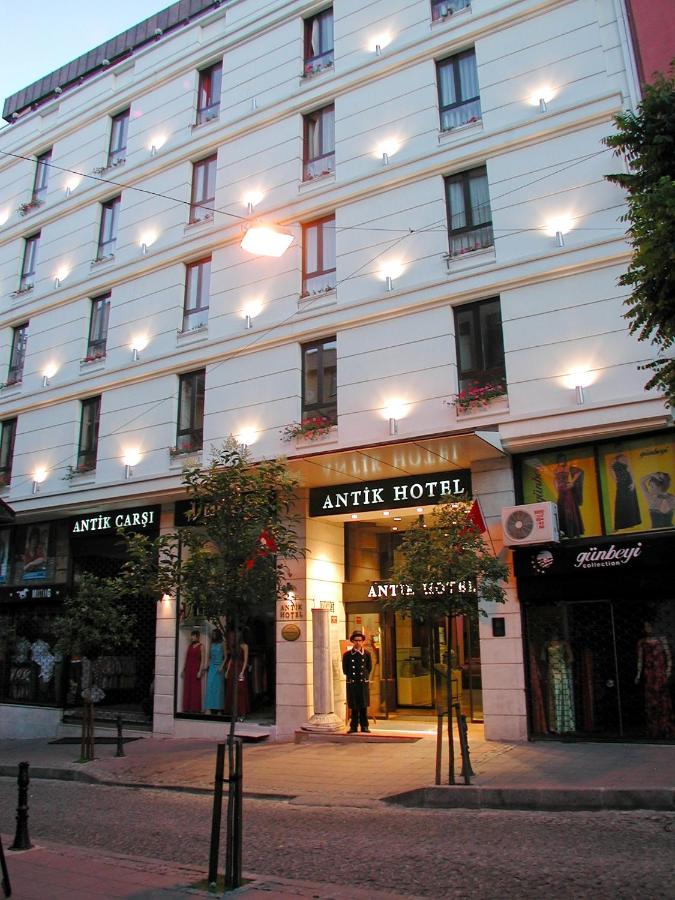 een man die voor een gebouw staat bij Antik Hotel Istanbul in Istanbul