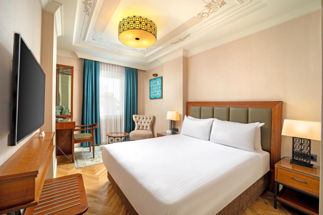 een hotelkamer met een bed en een televisie bij Golden Age Hotel Taksim in Istanbul