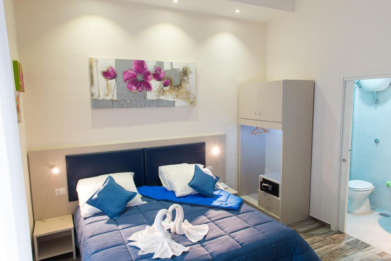 een slaapkamer met een blauw bed waarop handdoeken liggen bij Napoli's Gold in Napels