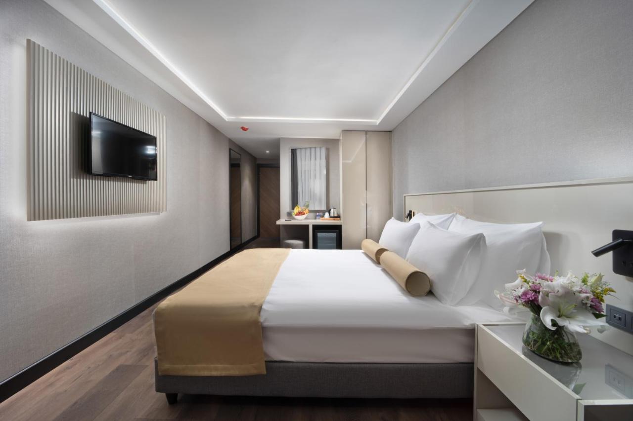 een slaapkamer met een groot bed en een tv aan de muur bij Pianoforte by Febor Hotels&Spa in Istanbul