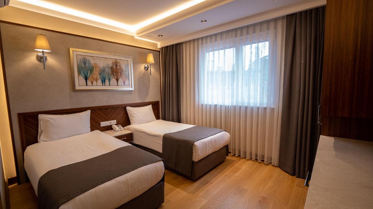 een hotelkamer met twee bedden en een raam bij Sogut Hotel Old City in Istanbul