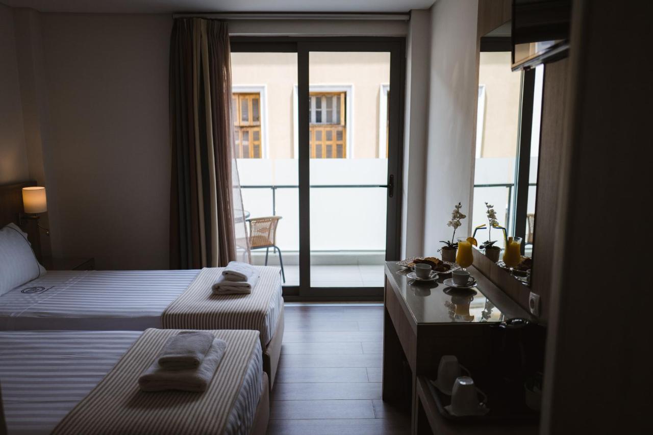 een hotelkamer met twee bedden en een balkon bij Piraeus Port Hotel in Piraeus +63 foto's
