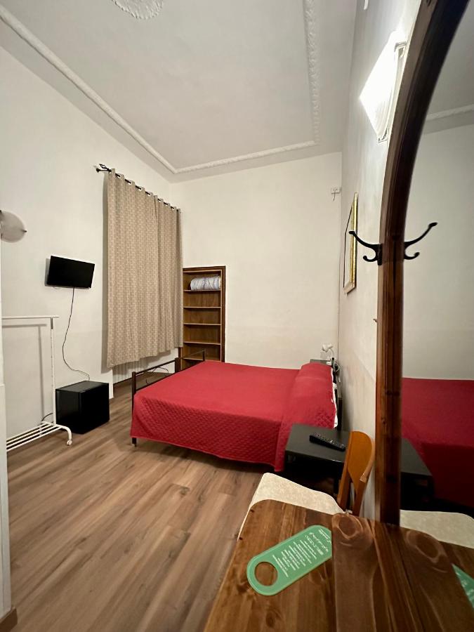 een slaapkamer met een rood bed en een houten vloer bij Hotel Il Papavero in Rome +12 foto's