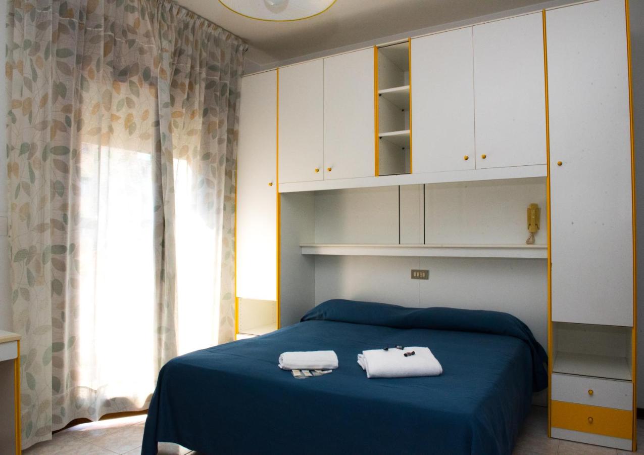 een slaapkamer met een blauw bed en witte kasten bij Hotel Malibran in Lido di Jesolo
