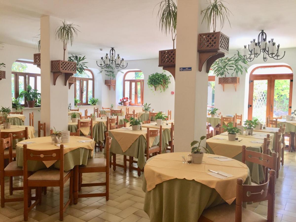 een eetkamer met tafels, stoelen en kroonluchters bij Villa Ciccio in Ischia Town