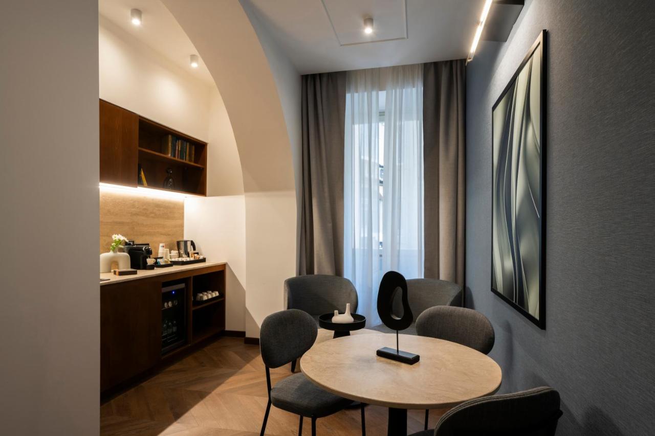 een kamer met een tafel en stoelen en een keuken bij Boutique Hotel Piedra Rome City Centre in Rome