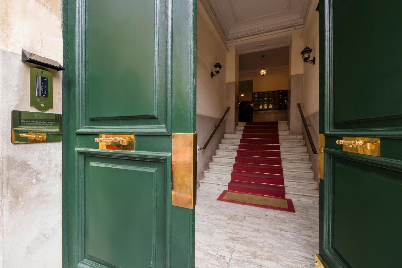 een gang met groene deuren en een rode loper bij Boutique Hotel Piedra Rome City Centre in Rome